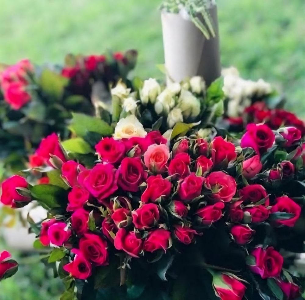 Bouquet of red, pink and white roses with greenery